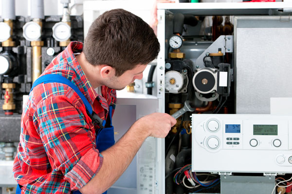 HVAC technician inspecting and repairing boiler controls in Erie