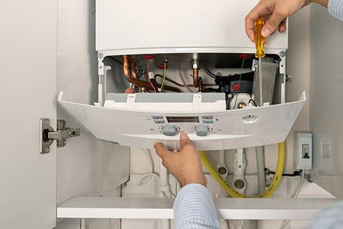 HVAC technician repairing an indoor boiler in Erie