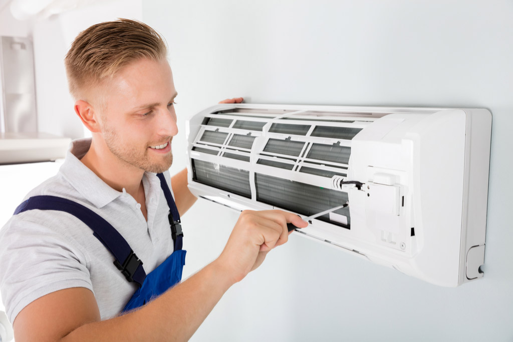 HVAC technician performing ductless air conditioning maintenance in Erie