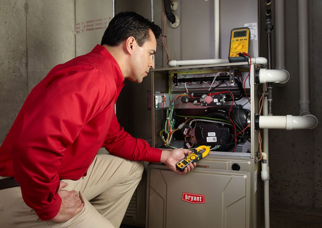 HVAC technician repairing an indoor furnace in Erie