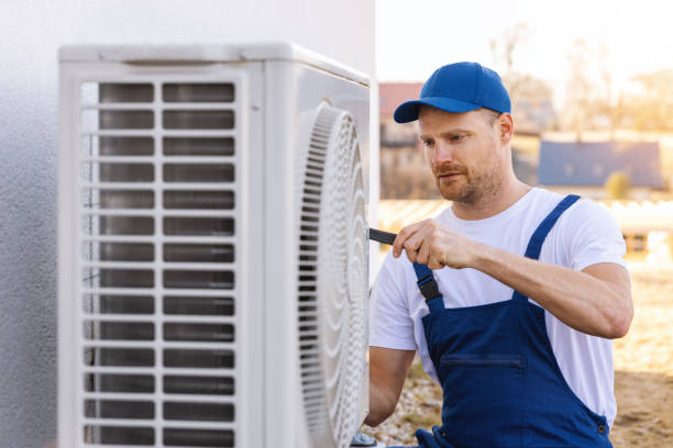 HVAC technician servicing an outdoor air conditioning unit in Erie