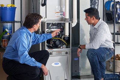 65df8c11f3e4c468cbd351a5_furnace repair vs replacement – Copy HVAC technician explaining furnace repair and maintenance to a homeowner in Erie, CO