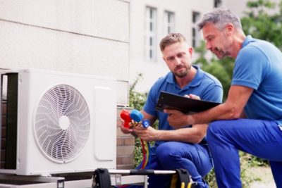 ac-installation-in-claremont-ca HVAC technicians reviewing an outdoor air conditioning unit in Erie, CO
