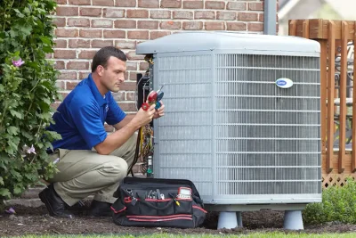 design-air-heating-and-air-conditioning-decatur-il-05 – Copy HVAC technician inspecting an outdoor air conditioning unit in Erie, CO