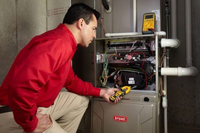 furnace repair Heating and air conditioning technician servicing an indoor furnace in Erie, CO